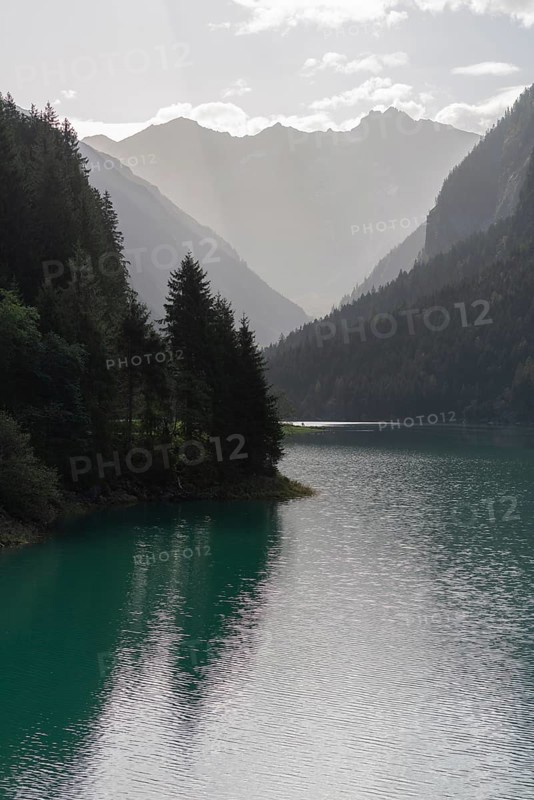 Stilluptal, reservoir Stiillup (1116m), Stillupgrund, Mayrhofen, reservoir lake, alpine mountain landscape, coniferous forest, backlight, water reflection, haze, Zillertal Alps, Tyrol, Austria, Europe