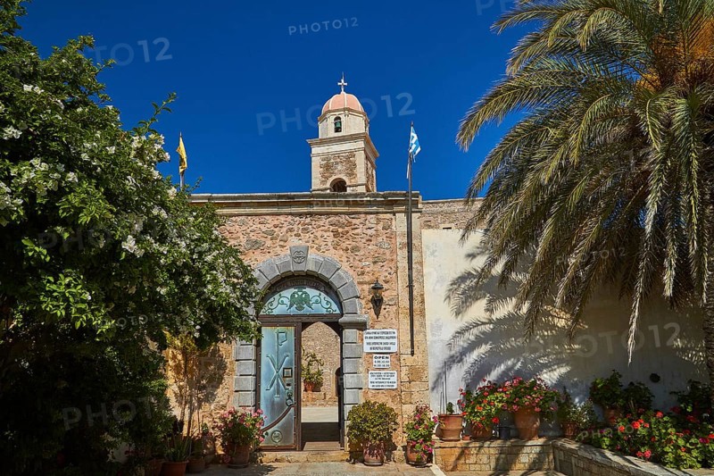 Entrance gate, blue door, bell tower, red dome, palm tree, blue cloudless sky, Toplou, Orthodox Monastery, East Crete, Lassithi Province, Crete, Greece, Europe