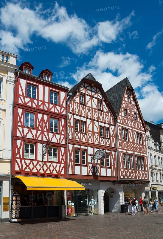 Medieval half-timbered houses in red and white with shops and passers-by under a clear sky, Hauptmarkt, Trier, Rhineland-Palatinate, Germany, Europe
