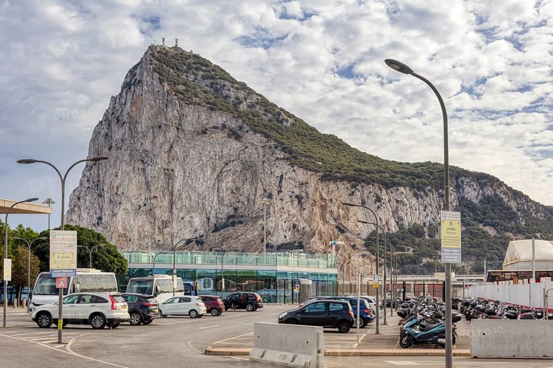 City view with prominent rock and passing cars under a cloudy sky, Gibraltar, Europe