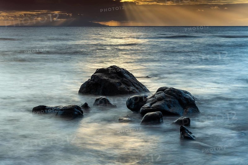 Rocks on the beach of Playa del Inglés. Sunset. Sea and waves. Long exposure. Valle Gran Rey, La Gomera, Canary Islands, Spain, Europe