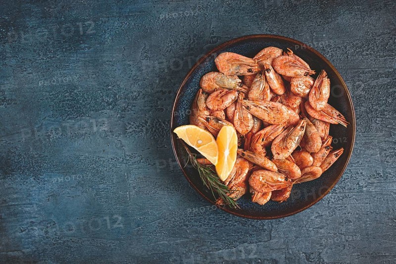 Fried shrimp, with shell and head, unpeeled, size 70-90, on a blue background, homemade, no people