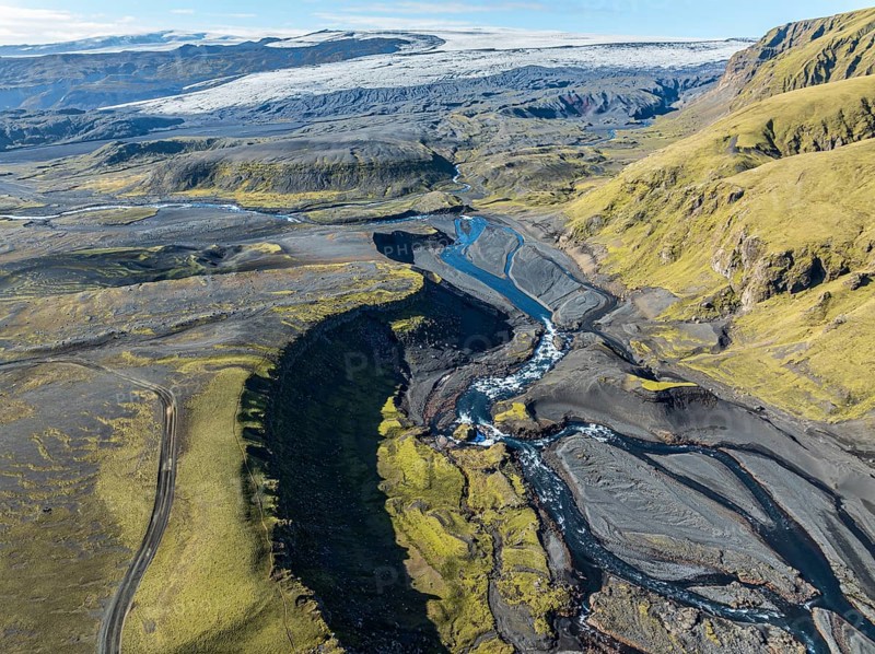 River along road F232 Öldufellsleid, slopes of Mt. Öldufell, moss-covered hill in black lava sand, aerial view, Iceland, Europe