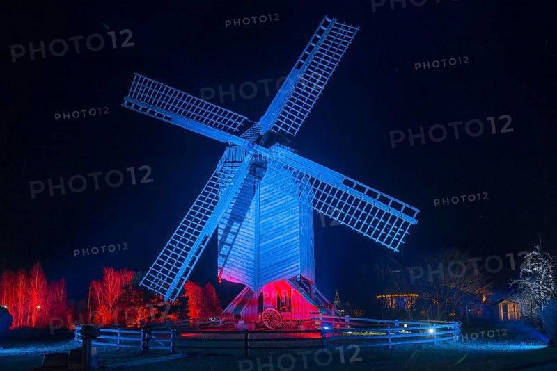 A large, blue-red illuminated windmill at night with a dark background, world of lights, illumination, mill museum, Gifhorn, Lower Saxony, Germany, Europe