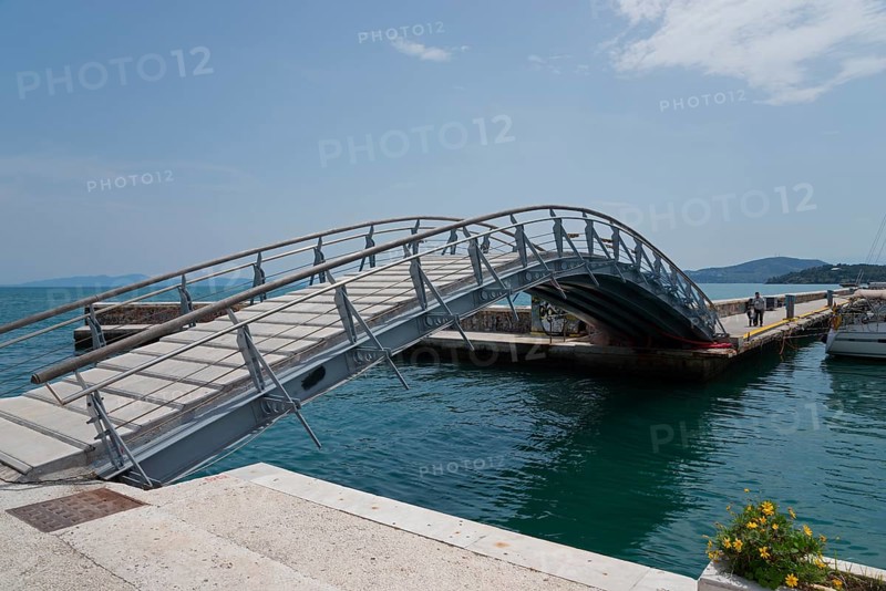 Arched bridge over the water with flower arrangement, surrounded by harbour and sky, Arched bridge, Volos, Pagasitic Gulf, Thessaly region, Greece, Europe