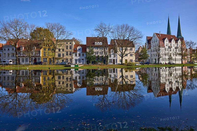 Riverbank of the Trave, historic houses, trees, church towers of Lübeck Cathedral, cloudless blue sky, symmetrical reflections on the water surface, Old Town, Hanseatic City of Lübeck, independent city, Schleswig-Holstein, Germany, Europe