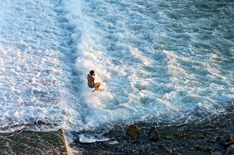 Girl bathing in the spray of the Lech weir, jumping into the white foaming water of the cascades, river Lech, Landsberg am Lech, Upper Bavaria, Bavaria, Germany, Europe