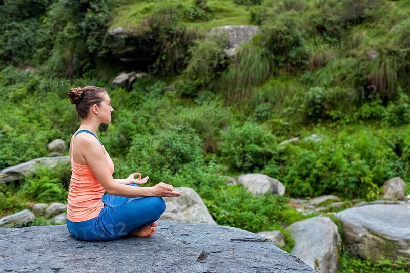 Woman in Hatha yoga asana Padmasana outdoors