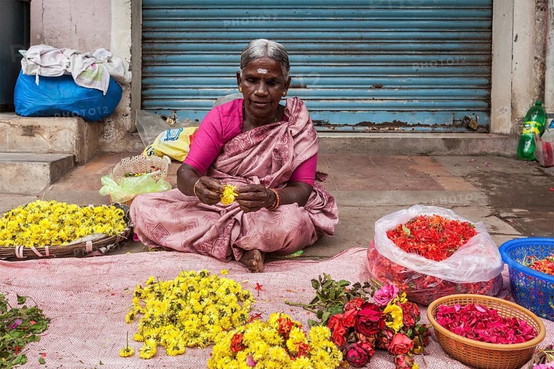 TIRUCHIRAPALLI, INDIA, FEBRUARY 14, 2013: Unidentified Indian woman, hawker (street vendor) of flowers for temple offerings
