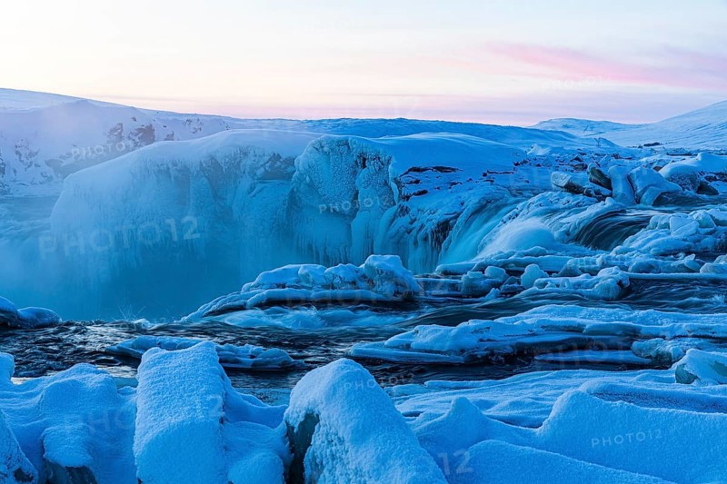 Icefall at the edge of the Godafoss waterfall at dawn, snow-covered landscape, Northern Iceland Eyestra, Iceland, Europe