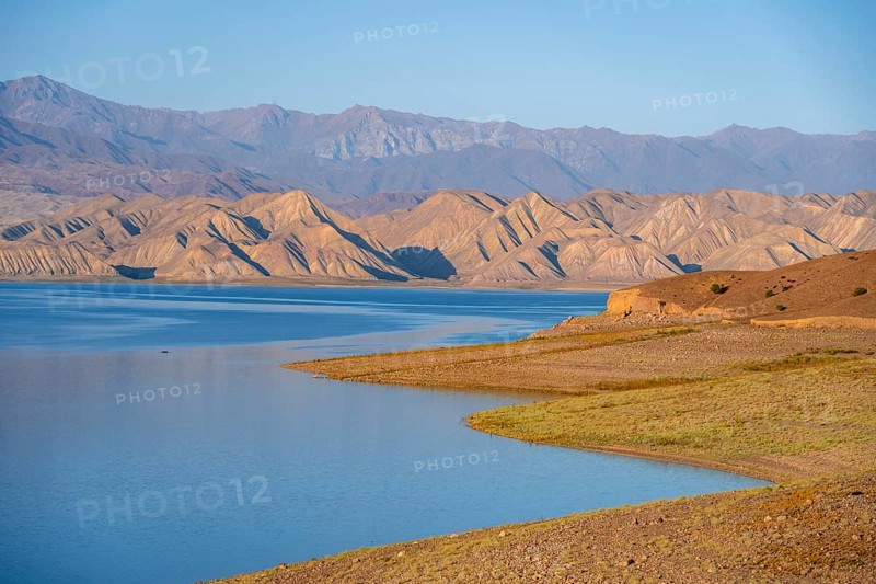 Blue Toktogul reservoir between dry mountain landscape, hilly mountains in the evening light, Jalalabad region, Kyrgyzstan, Asia