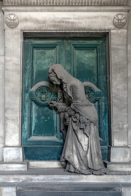 Sculpture of an old woman at a door with an hourglass, Monumental Cemetery, Cimitero monumentale di Staglieno), Genoa, Italy, Europe