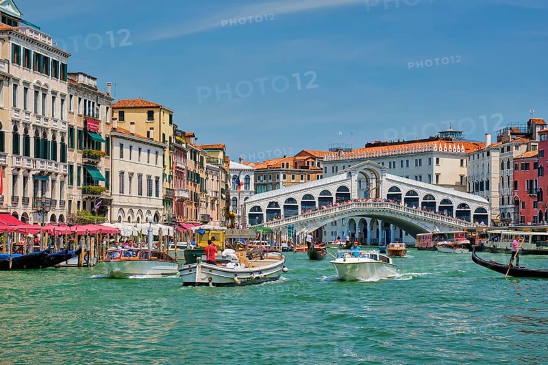 VENICE, ITALY, JULY 19, 2019: Rialto bridge with boats and gondolas passing under on Grand Canal, Venice, Italy, Europe