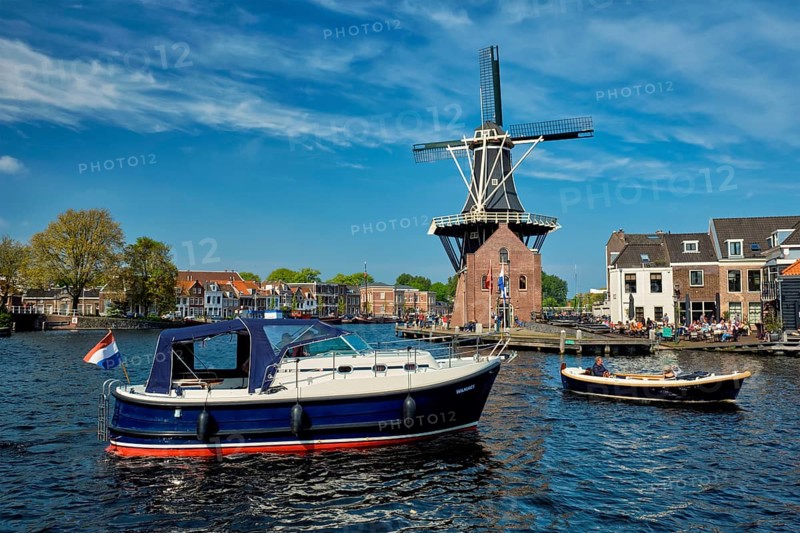 HAARLEM, NETHERLANDS, MAY 6, 2017: Harlem cityscape with windmill De Adriaan on Spaarne river. Haarlem, Netherlands
