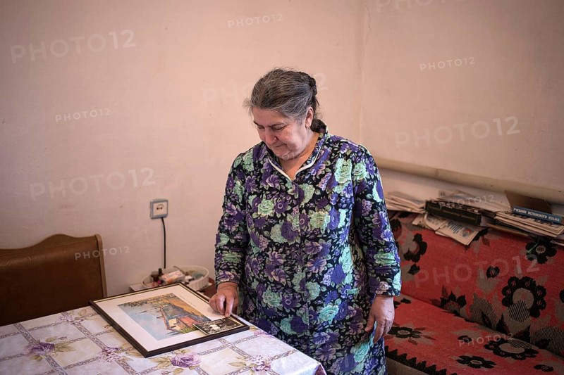 A Crimean Tatar woman in her home looks at a picture of her family's house in front of deportation to Uzbekistan, Crimea, Ukraine, Europe
