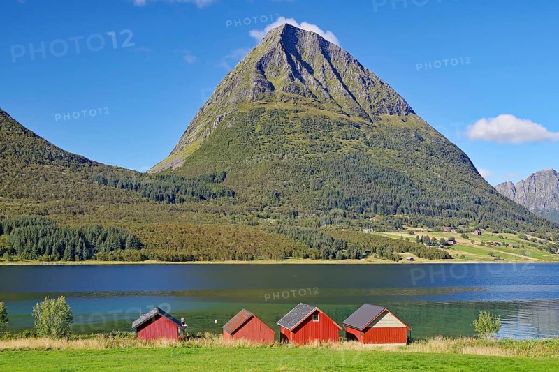 Steep mountains and red wooden sheds on the shore of a fjord, Aldersund, FV 17, Kystriksveien, Nordland, Norway, Europe
