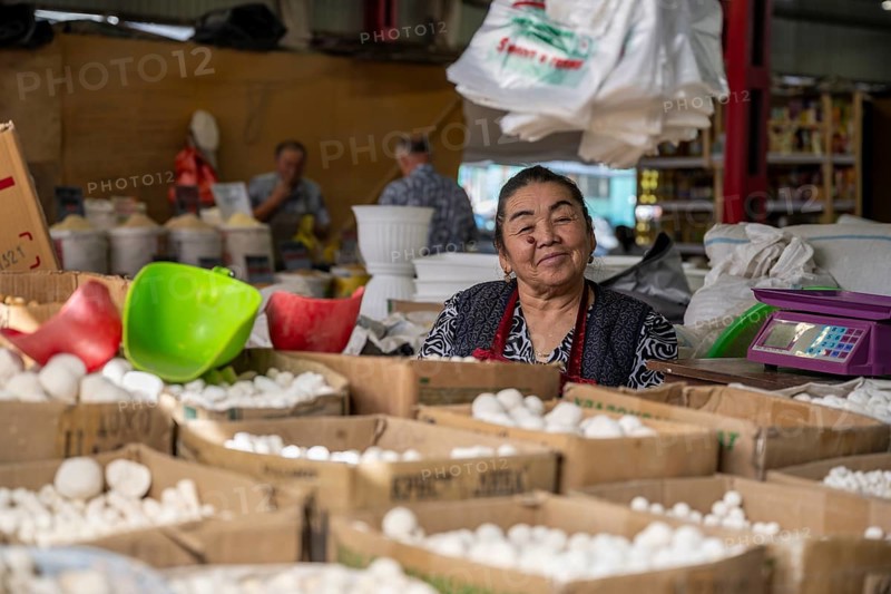 Traditional woman selling food, market stall at Osh Bazaar, Bishkek, Kyrgyzstan, Asia