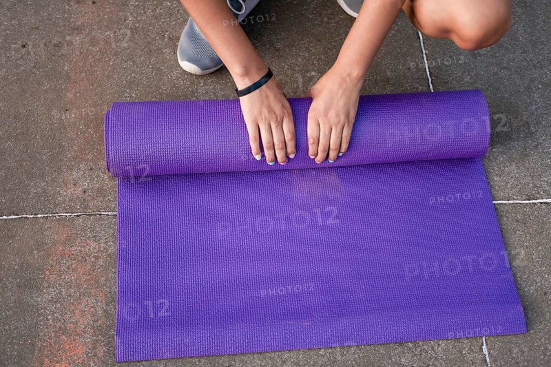 Woman hands rolling up the mat outside. Athlete woman hands rolling up the mat after exercising. Concept of rolling up mat after exercise, Managua, Nicaragua, Central America