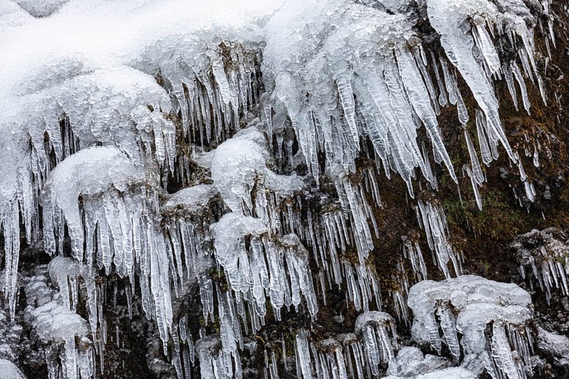 Icicles on the rock face at Skogafoss waterfall, Sudurland, Iceland, Europe