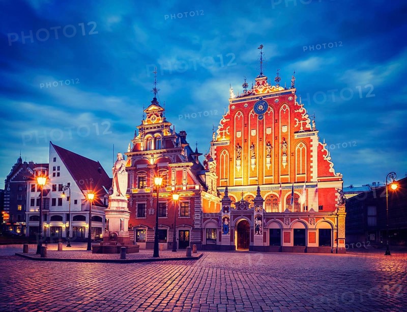 Vintage retro effect filtered hipster style image of Riga Town Hall Square, House of the Blackheads and St. Roland Statue illuminated in the evening twilight, Riga, Latvia, Europe
