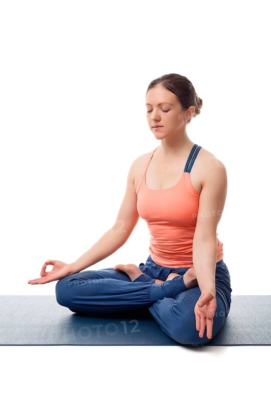 Beautiful fit yogini woman meditating in yoga asana Padmasana (Lotus pose) cross legged position for meditation with Chin Mudra, psychic gesture of consciousness, isolated on white background