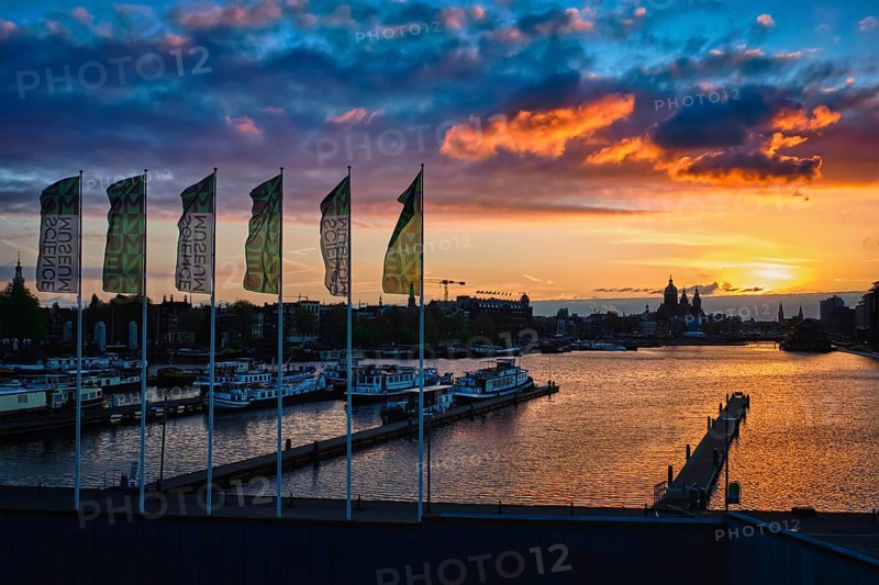 AMSTERDAM, NETHERLANDS, MAY 9, 2018: Amsterdam cityscape skyline with Church of Saint Nicholas (Sint-Nicolaaskerk) on sunset with dramatic sky from Nemo Science Museum. Amsterdam, Netherlands