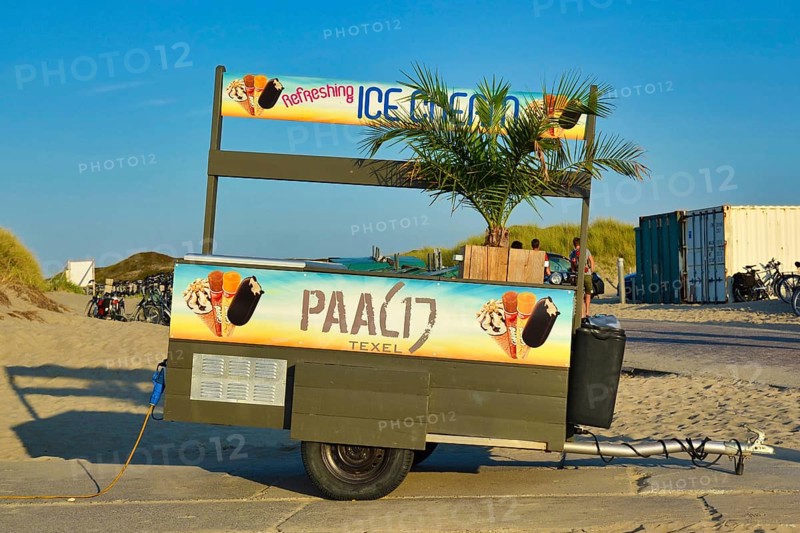 Texel, Netherlands, August 2019: Tropical ice cream truck trailer with palm tree standing at the Paal 17 beach of island Texel