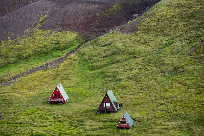 Cabins among volcanic landscape with black sand and green grass, Ásgarður, Kerlingarfjöll, Icelandic Highlands, Iceland, Europe