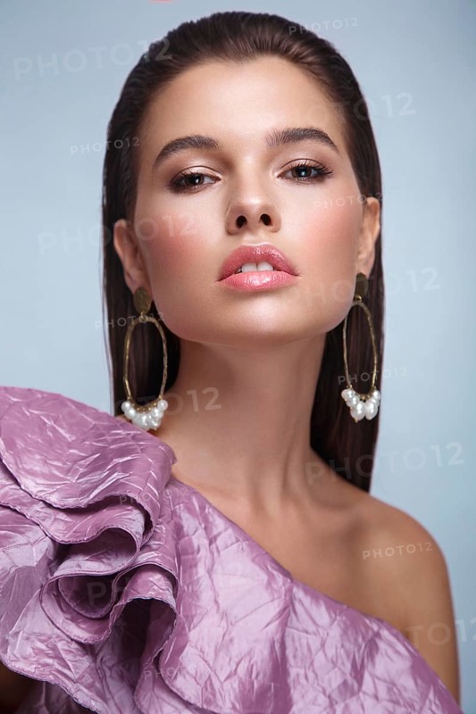 Beautiful fresh girl with classic make-up, smooth hair in a purple dress. Beauty face. Photo taken in studio
