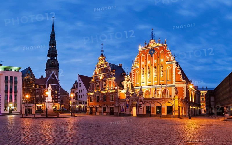 Panorama of Riga Town Hall Square with House of the Blackheads, St. Roland Statue and St. Peter's Church illuminated in the evening, Riga, Latvia, Europe