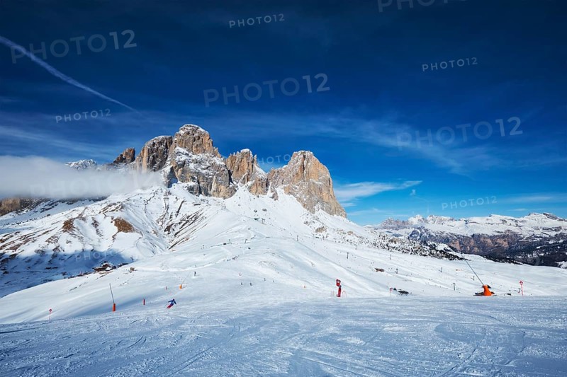 View of a ski resort piste with people skiing in Dolomites in Italy