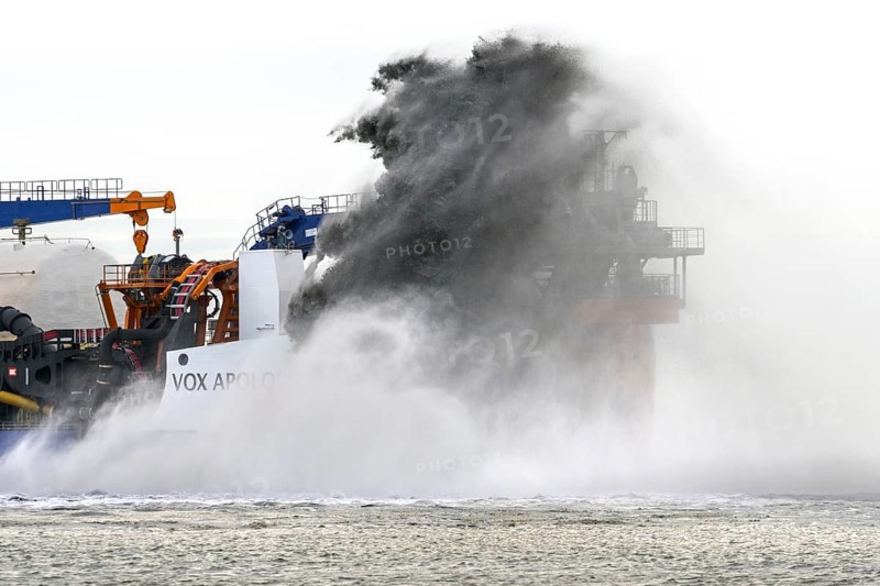 Trailing suction hopper dredger Vox Apolonia of Van Oord, Dutch maritime contracting company specialized in dredging, rainbowing along Zeeland coast