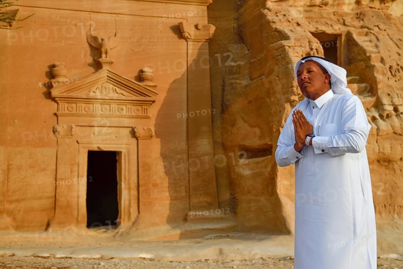 Rawi, storyteller, in front of the Nabataean tombs at the rock Qasr Al-Bint, Hegra or Madain Salih, AlUla region, Medina province, Saudi Arabia, Arabian Peninsula, Asia