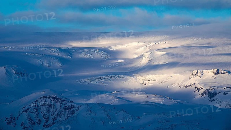 Light and shadow over the snowy hills and mountains of Myrdalsjökull, Sudurland, Iceland, Europe