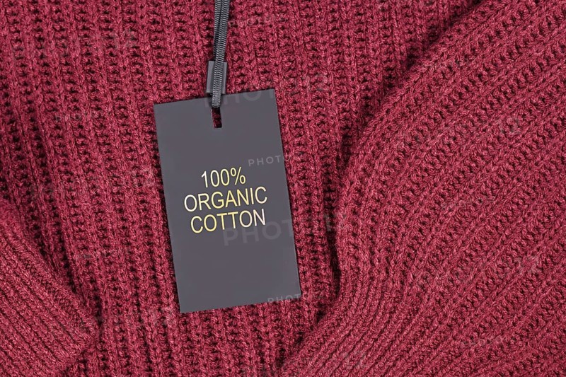 Label saying '100% organic coton' attached to environmental friendly produced pullover