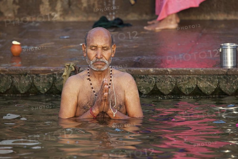 Indian man bathing and praying in the Ganges river at a ghat at Varanasi, Uttar Pradesh, India, Asia