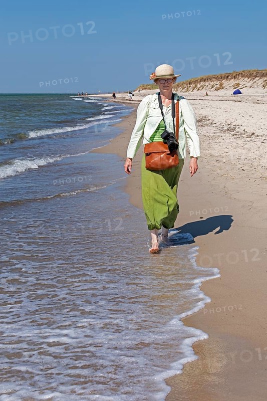 Elderly woman walking barefoot on the beach, Darßer Ort, Born a. Darß, Mecklenburg-Vorpommern, Germany, Europe