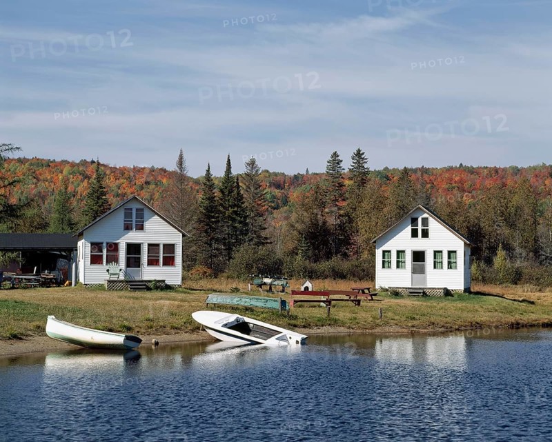 Small country chalets with boats on lake shoreline in autumn, Chertsey, Lanaudiere, Quebec, Canada, North America