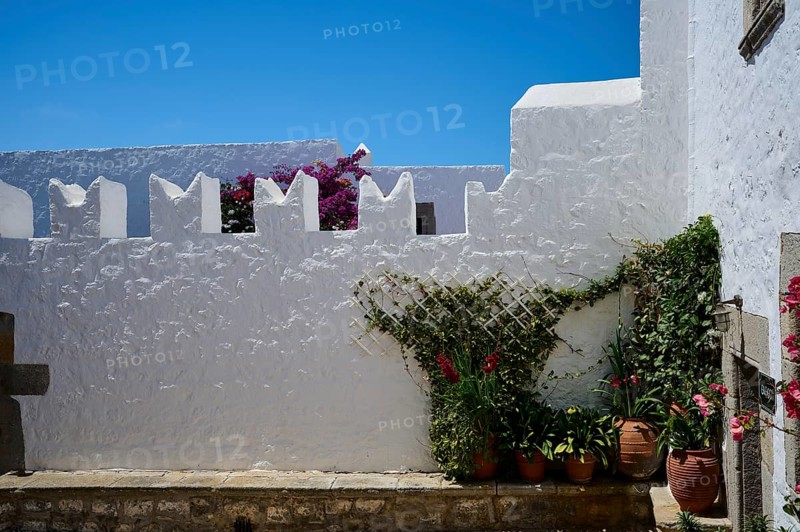 Courtyard with white walls and flowering plants in terracotta pots, Zoodochou Pigis Monastery, The Springs of Life, Chora, Patmos, Dodecanese, Greek Islands, Greece, Europe