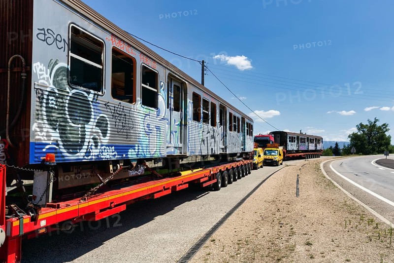Heavy goods transport parked at the roadside, discarded train wagons, wagon with graffiti, escort vehicles, France, Europe