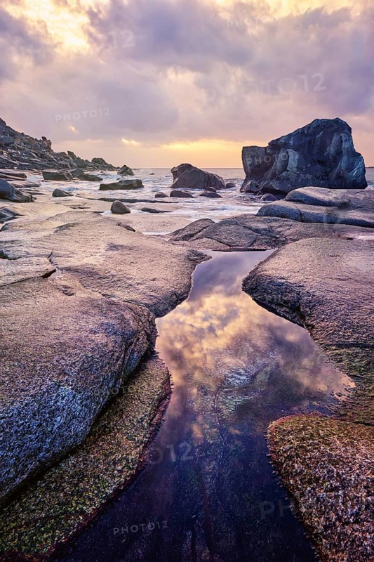 Rocks on beach of fjord of Norwegian sea in winteron sunset. Utakliev beach, Lofoten islands, Norway, Europe