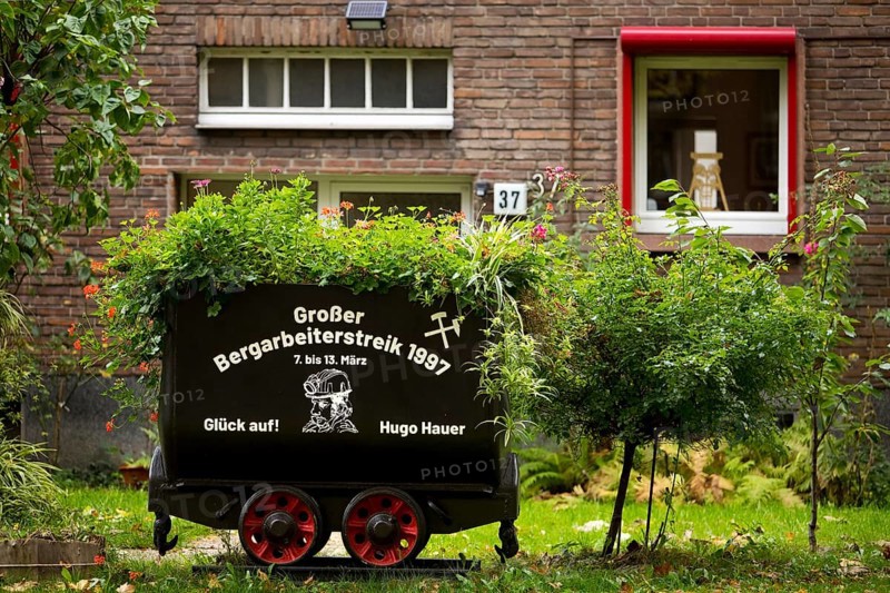 Coal lorry in the front garden commemorating the big miners' strike in 1997, Gelsenkirchen, Ruhr area, North Rhine-Westphalia, Germany, Europe