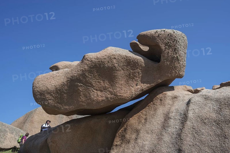 Tourists visiting strange rock formations due to wind and water erosion along the Côte de granit rose, Pink Granite Coast at Ploumanac'h, Brittany, France, Europe