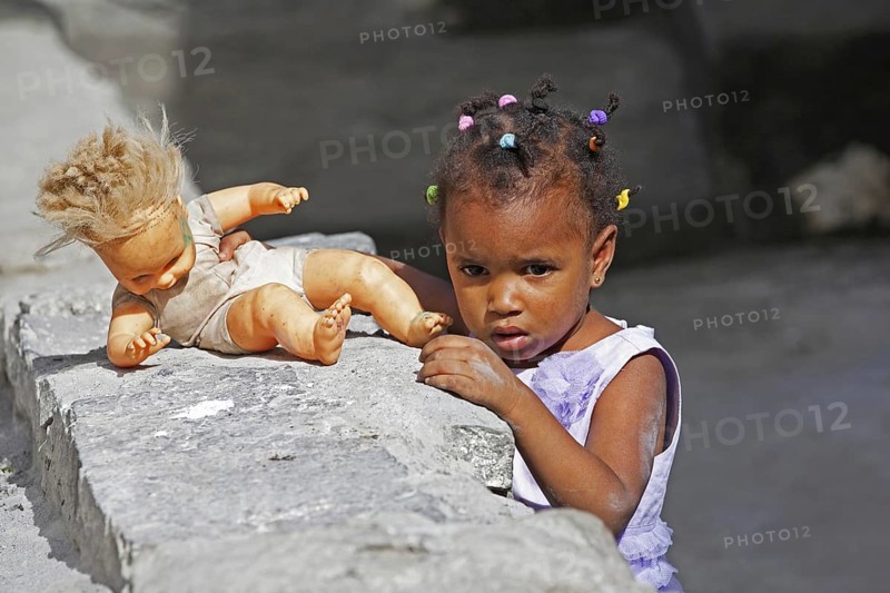 Creole girl with braided hair playing with doll on the island Santo Antão, Cape Verde, Cabo Verde, Western Africa, Africa