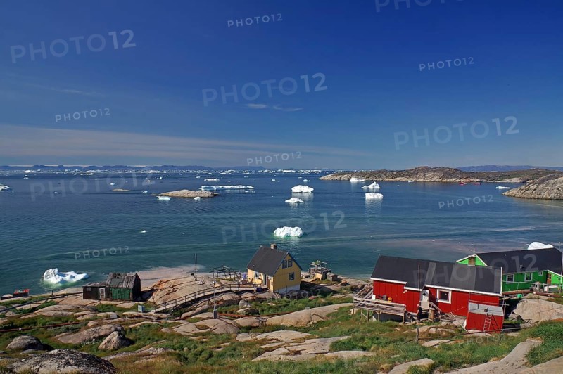 Simple, colourful houses on the edge of a bay covered with icebergs, Ilulissat, Arctic, Disko Bay, Greenland, Denmark, North America