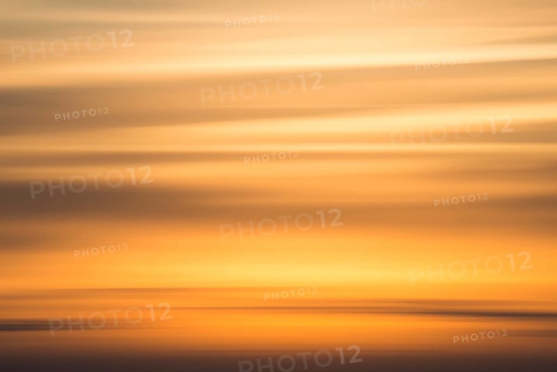 Orange-coloured evening sky with clouds near Lüneburg shortly after sunset, wiping effect, Lower Saxony, Germany, Europe