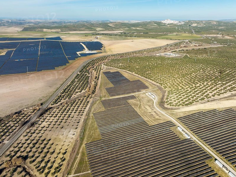Rows of solar panels at a photovoltaic plant and the town of Espejo in the distance, aerial view, drone shot, Córdoba province, Andalucía, Spain, Europe