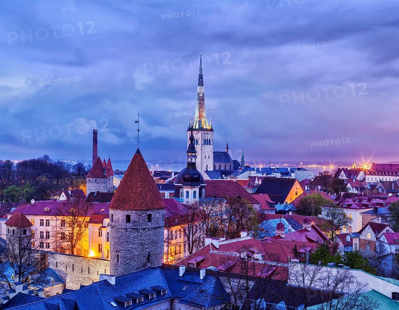 Aerial view of Tallinn Medieval Old Town with St. Olaf's Church and Tallinn City Wall illuminated in evening, Estonia, Europe