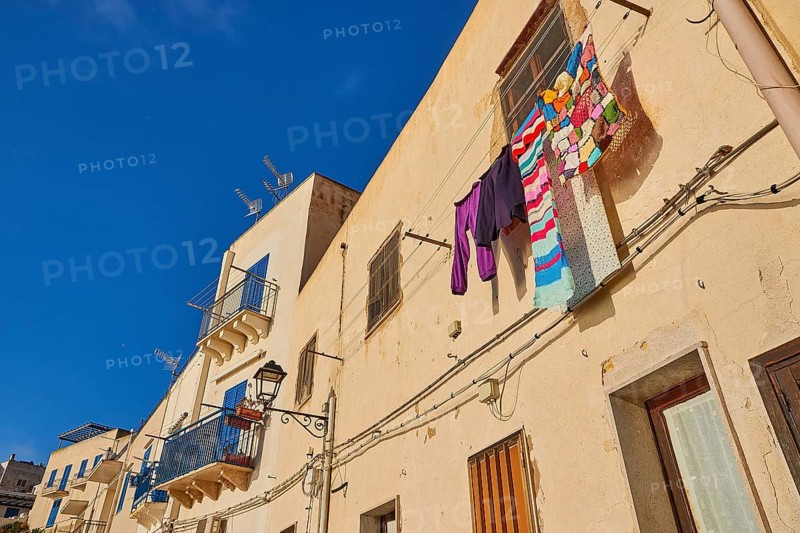 Morning light, row of houses, colourful houses, balconies, laundry on line, Levanzo town, main town, Levanzo, Egadi Islands, Sicily, Italy, Europe