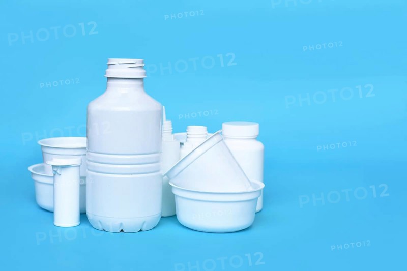 Different empty plastic waste packages on blue background with negative space